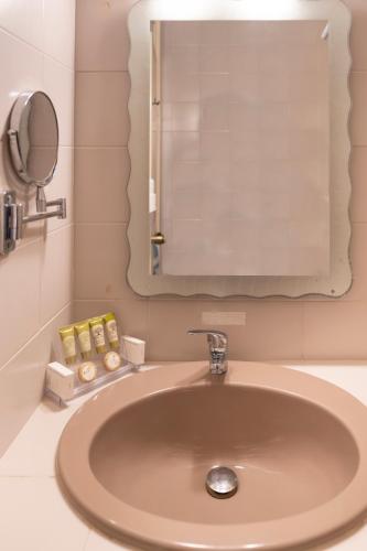 a bathroom with a sink with a mirror and soap at Agia Markella in Chios