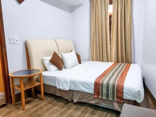 a bedroom with a bed and a table and a window at Home Stay Sen biển in Ấp Thiện Phước