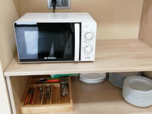 a microwave oven sitting on top of a shelf at PENSION PORTA SANTA in Baleira