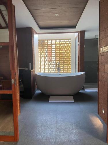 a large bath tub in a room with a window at GReaT Trails Wayanad by GRT Hotels in Wayanad