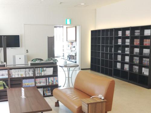a library with a couch and a table and bookshelves at Hotel Hakusan Hills in Hakusan