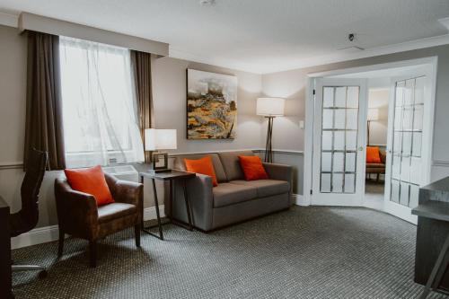 a living room with a couch and a chair at Crowne Plaza Fredericton Lord Beaverbrook by IHG in Fredericton