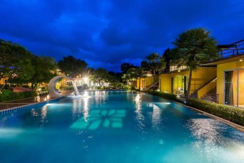 a swimming pool at night with a fountain at BANGKOK.GRAND.RESORT in Bang Bo