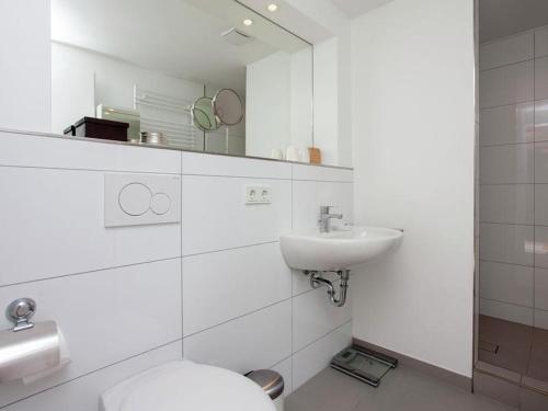 ein weißes Badezimmer mit Toilette und Waschbecken in der Unterkunft Zeelicht in Noordwijkerhout