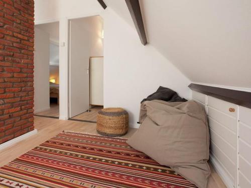 een kamer met een kussen op de vloer en een bakstenen muur bij Zeelicht in Noordwijkerhout