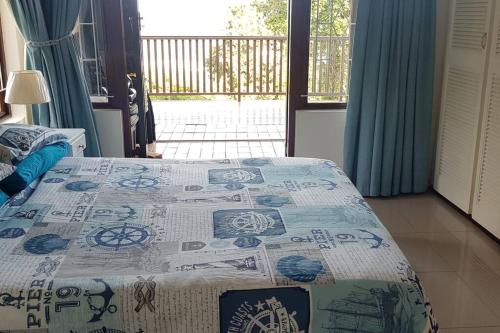 a bedroom with a bed with a blue and white quilt at On The Beach @ South Sands.No 2 in Port Edward