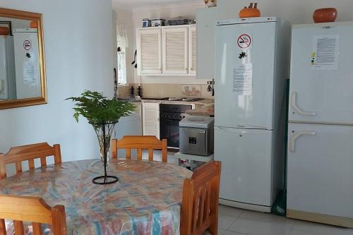 a kitchen with a table and white appliances at On The Beach @ South Sands.No 2 in Port Edward