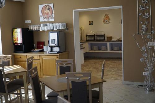 a dining room with tables and a kitchen with a counter at Pension-Ferienwohnung Rotar in Faak am See