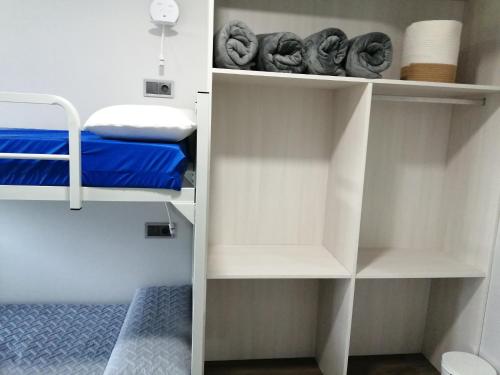 Habitación pequeña con estanterías blancas y cama en PENSION PORTA SANTA en Baleira