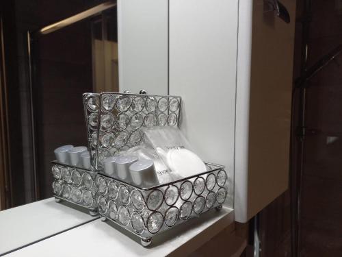 un contenitore di spazzole per capelli e uno specchio su un bancone di Studio Acasă a Sibiu