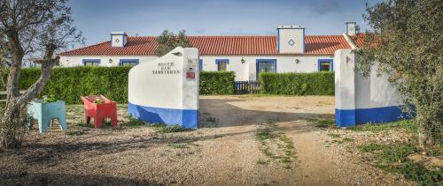 a building with a gate in front of a house at Monte Varginhas Porto Covo in Porto Covo
