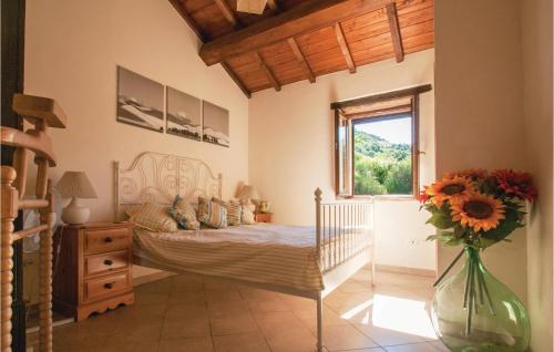 1 dormitorio con 1 cama y un jarrón de flores en Casa Noce en SantʼApollinare in Girfalco