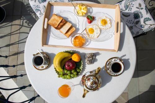 a table with a breakfast of eggs and fruit at Dileep Kothi - A Royal Boutique Luxury Suites in Jaipur in Jaipur