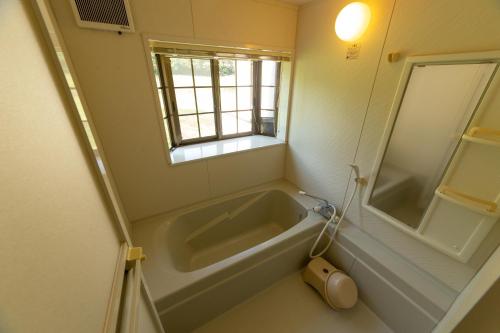 a bath tub in a bathroom with a window at Minami Aso Luna Observatory Auberge Mori no Atelier in Minami Aso