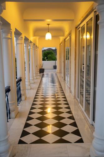 a hallway with a black and white checkered floor at Dileep Kothi - A Royal Boutique Luxury Suites in Jaipur in Jaipur