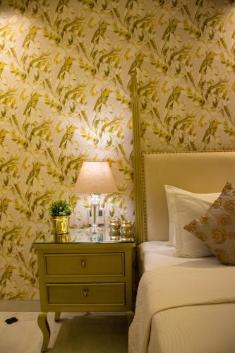 a bedroom with a bed and a table with a lamp at Dileep Kothi - A Royal Boutique Luxury Suites in Jaipur in Jaipur