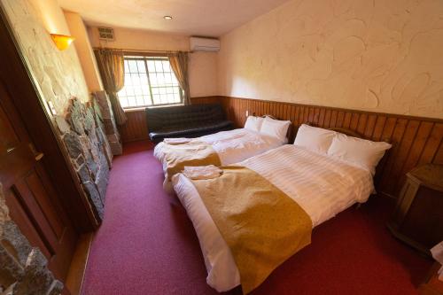 a bedroom with a bed and a chair in it at Minami Aso Luna Observatory Auberge Mori no Atelier in Minami Aso