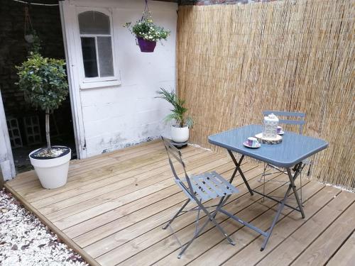une table bleue et une chaise sur une terrasse dans l'établissement Escapades Douaisiennes, à Douai