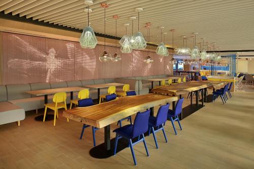 a restaurant with wooden tables and blue chairs at Holiday Inn Express Kuala Lumpur City Centre by IHG in Kuala Lumpur