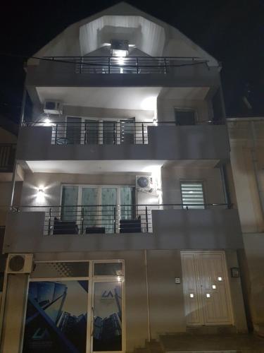 ein Gebäude mit zwei Balkonen in der Nacht in der Unterkunft Family Apartmani Le in Leskovac