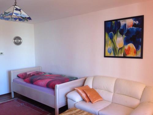 Zimmer mit einem Bett, einem Sofa und einem Gemälde in der Unterkunft Apartment Nürnberg-City in Nürnberg