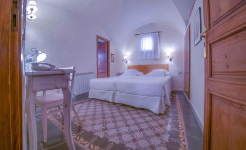 1 dormitorio con cama, mesa y escritorio en Can Bayre-Casa Rural en Fortiá