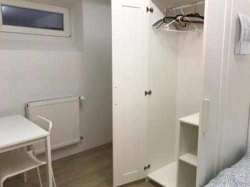 a bedroom with a white closet and a table and chair at Brahms 25 in Regensburg