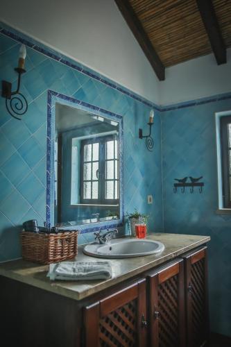 a bathroom with a sink and a mirror at Monte Varginhas Porto Covo in Porto Covo