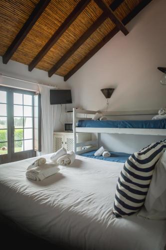 a bedroom with a large bed with two bunk beds at Monte Varginhas Porto Covo in Porto Covo