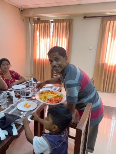 a man and a child sitting at a table with a plate of food at Yal's Town Inn in Jaffna