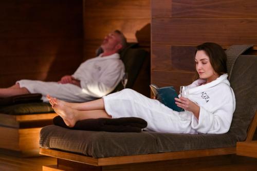 two people sitting in beds in a room at Killarney Plaza Hotel & Spa in Killarney