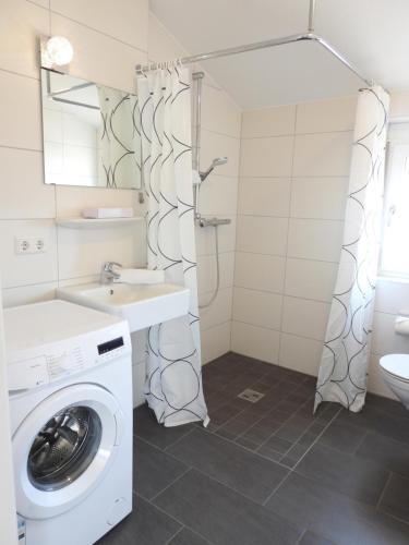 a bathroom with a washing machine and a sink at Braviscasa - Ferienresidenz Haus am Bach Vogtsburg am Kaiserstuhl in Vogtsburg