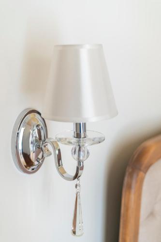 a silver lamp with a white lamp shade on a wall at Agia Markella in Chios