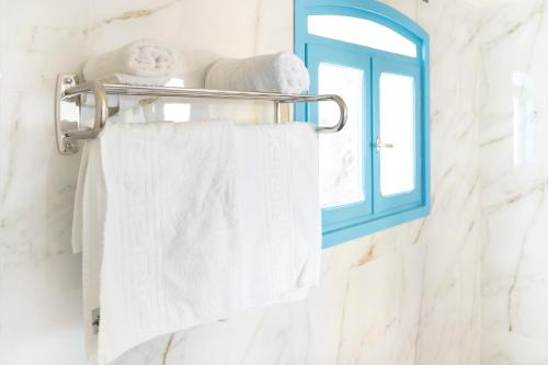 a towel rack with towels and a window in a bathroom at Agia Markella in Chios