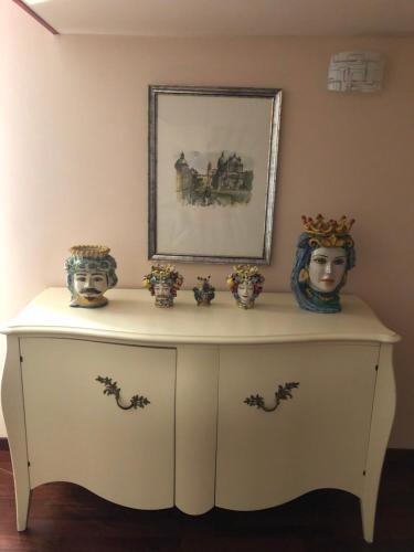 um armário branco com dois vasos e uma fotografia. em Zappala' Gemelli House em Catânia