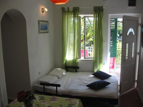 1 dormitorio con 2 camas y ventana en Apartments Zora, en Pirovac