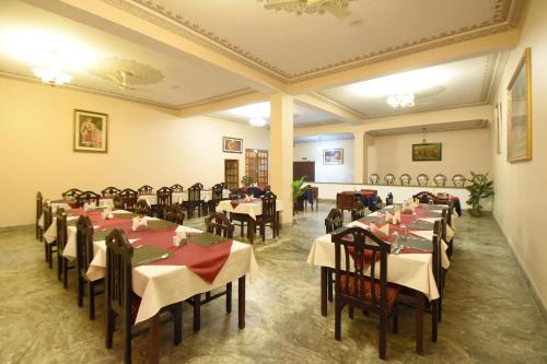 a restaurant with tables and chairs in a room at Satyam Palace Resort in Pushkar