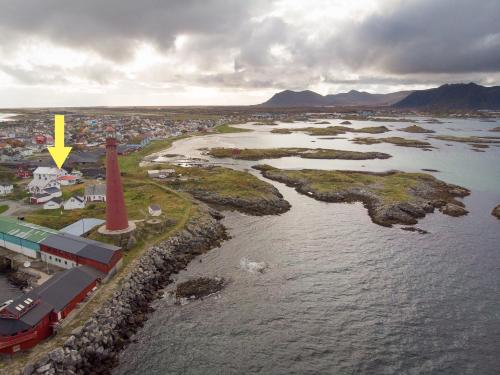 an island with a lighthouse in the water with a yellow arrow at Apt 103 - Andenes Whale Safari Apartments in Andenes