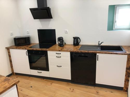 - une cuisine avec un comptoir, un évier et une cuisinière dans l'établissement Au pied de la plage, à Sangatte