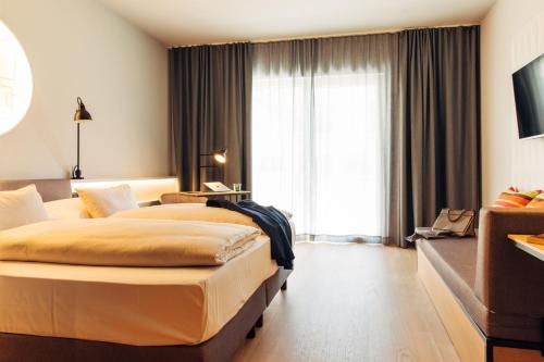 a hotel room with two beds and a window at harry's home Telfs hotel & apartments in Telfs