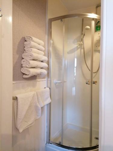 a shower in a bathroom with white towels at Broomfield House Bed and Breakfast in Earlston