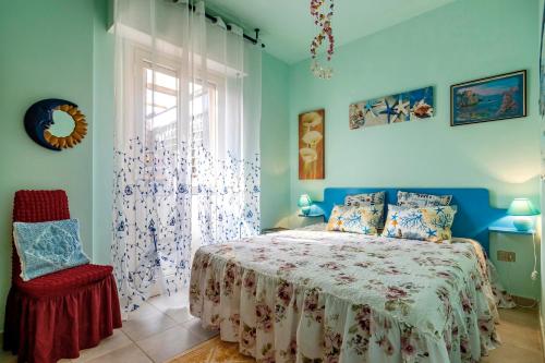 ein Schlafzimmer mit einem Bett, einem Stuhl und einem Fenster in der Unterkunft Casa Erica in Stintino