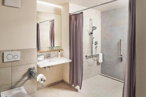 a bathroom with a shower and a sink and a shower at Seehörnle Bio Hotel & Gasthaus in Gaienhofen