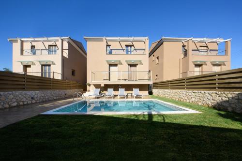 um edifício com piscina em frente a um edifício em Efilenia Luxury Villas em Corfu Town