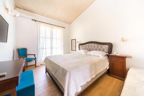 a bedroom with a bed and a desk and a television at Agia Markella in Chios