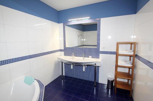 baño azul y blanco con lavabo y bañera en Apartmán U krále - 3, en Jičín