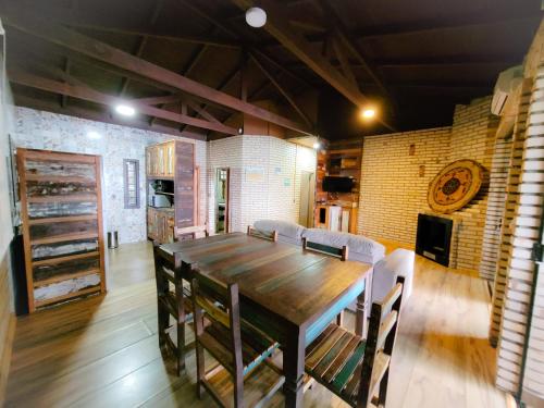 a dining room with a wooden table and chairs at Paraíso das Tartarugas in Bombinhas