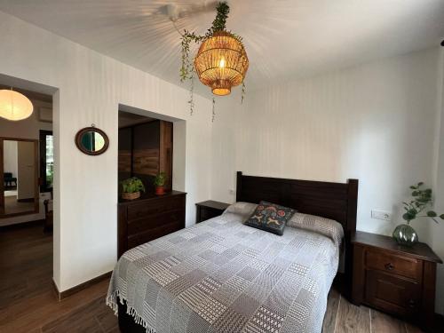 a bedroom with a bed and a chandelier at Casita con encanto a 200m de la playa in Alicante