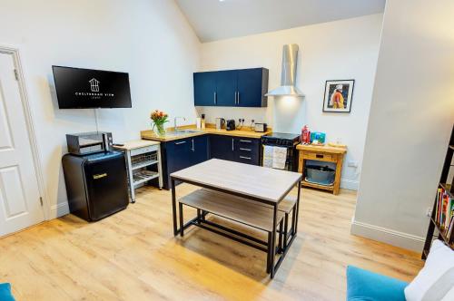 a kitchen with blue cabinets and a table in a room at Cheltenham View Lodge in Cheltenham