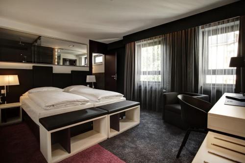 a hotel room with a bed and a chair at Bliss Design Hotel - Frankfurt City Messe in Frankfurt/Main